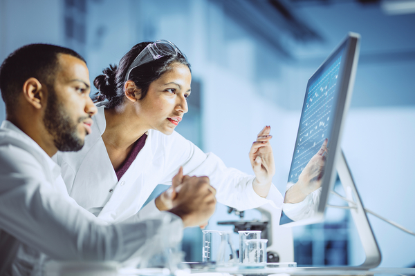 Scientists Working in The Laboratory pointing at a computer screen reading findings